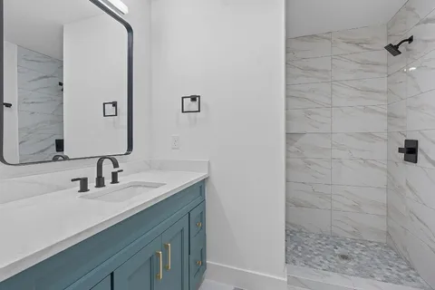 a bathroom with a sink a mirror and shower