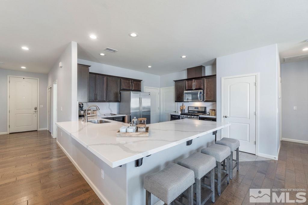2297 Dominic Drive Reno, NV 89521 - Photo 8 of 23 a large kitchen with kitchen island white cabinets and stainless steel appliances