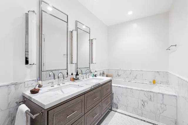 a large white bed sitting in a bedroom next to a window