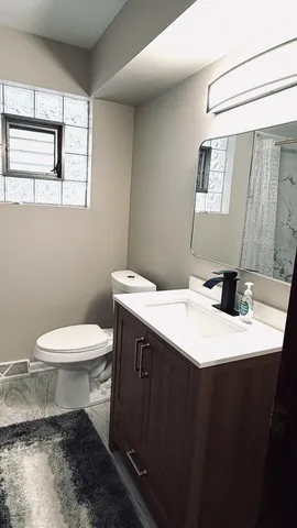 a bathroom with a sink a toilet and mirror