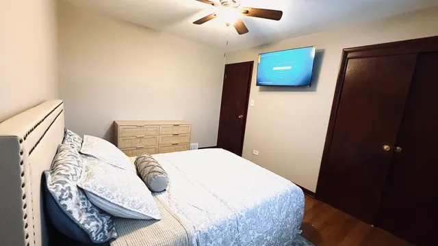 a bedroom with a bed and a ceiling fan