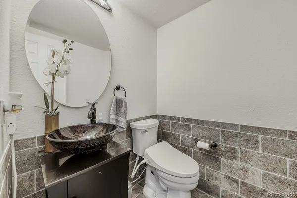 a bathroom with a granite countertop toilet and a mirror