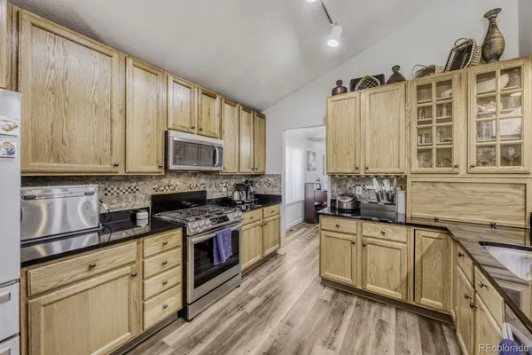 a kitchen with stainless steel appliances white cabinets a sink and a stove
