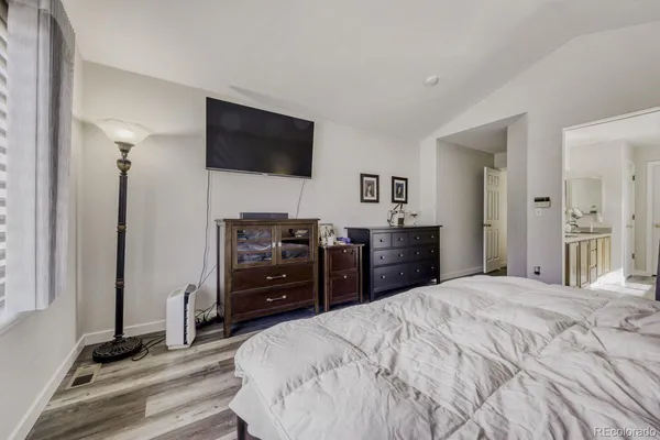 a large bedroom with a bed and flat screen tv