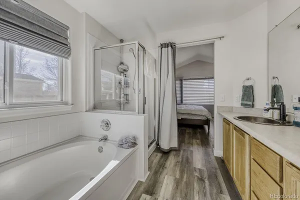 a bathroom with a tub sink and mirror