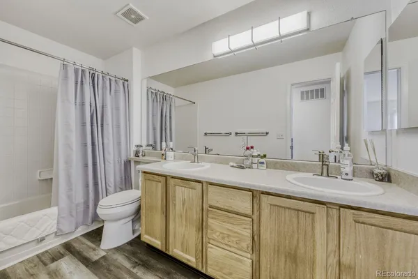 a bathroom with a double vanity sink toilet and a mirror