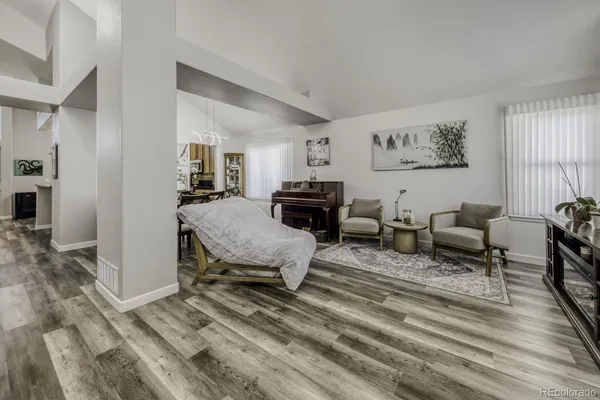 a living room with furniture and a wooden floor