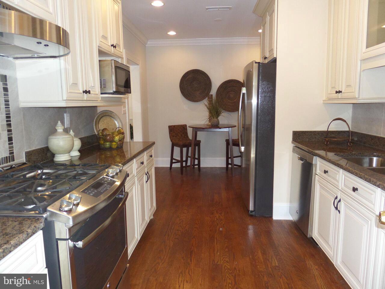 1326 Rittenhouse Street Northwest Washington, DC 20011 - Photo 8 of 28 a kitchen with stainless steel appliances granite countertop a stove top oven a sink dishwasher and cabinets with wooden floor