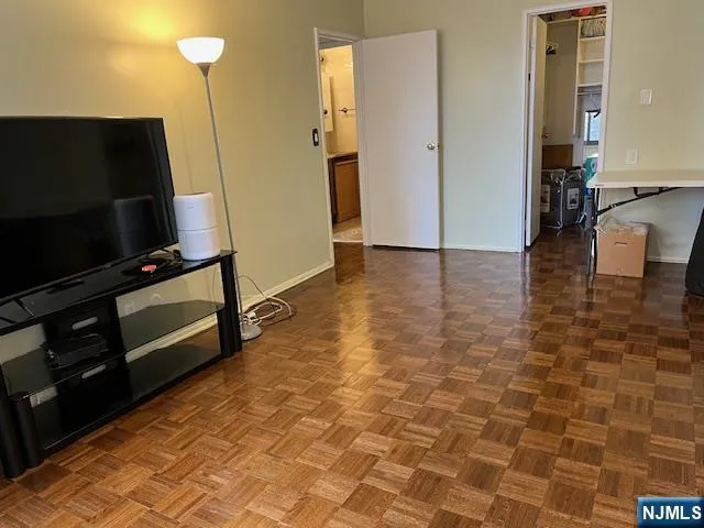 a view of a livingroom with wooden floor and a flat screen tv