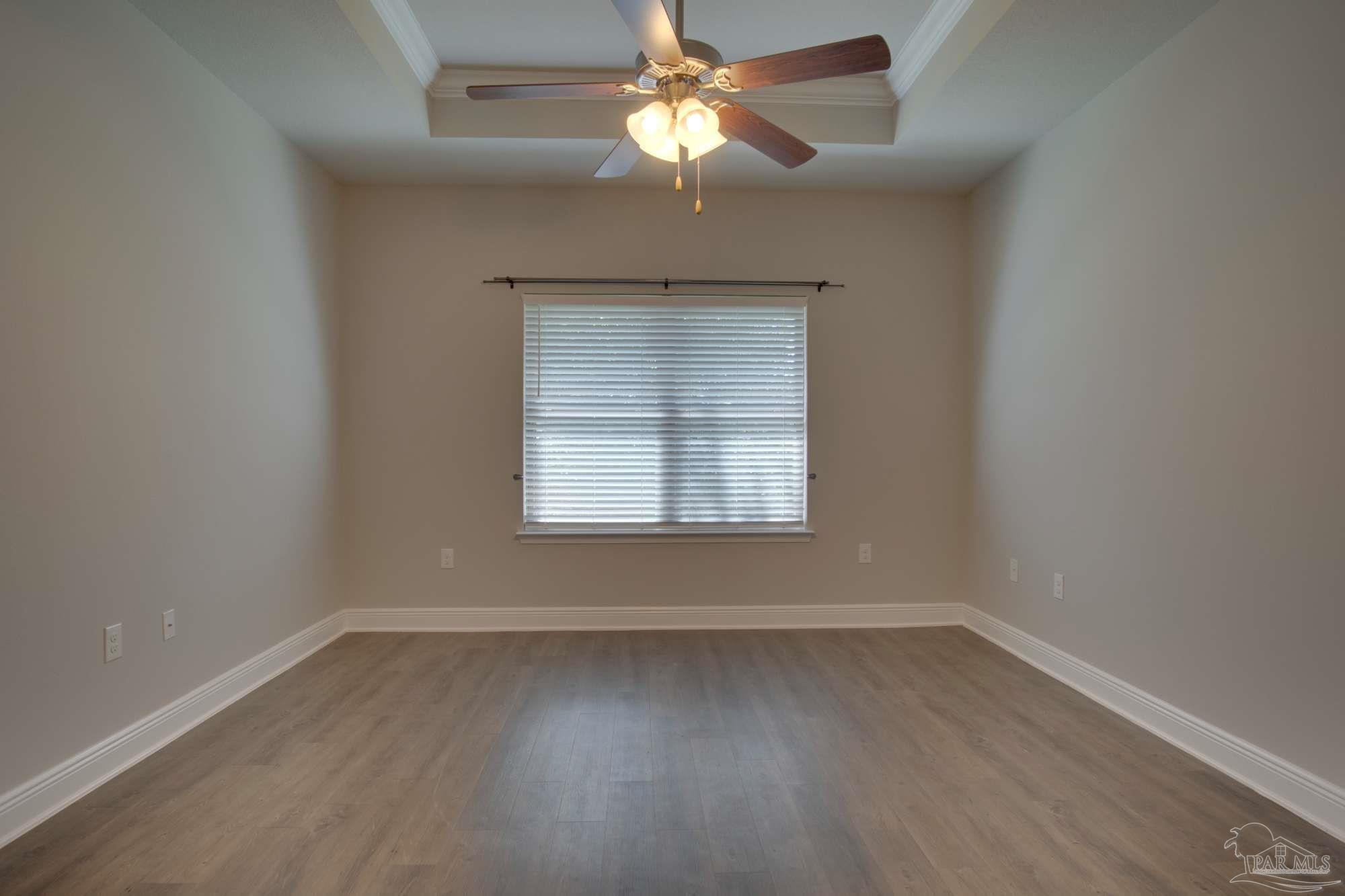 6239 Ladera Trail Pace, FL 32571 - Photo 15 of 27 an empty room with wooden floor chandelier fan and windows