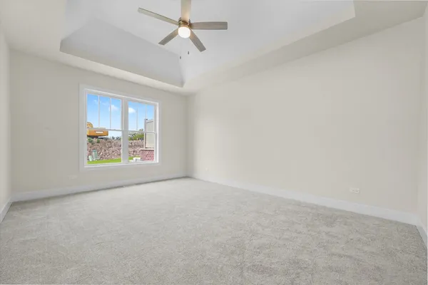 an empty room with a window and a ceiling fan