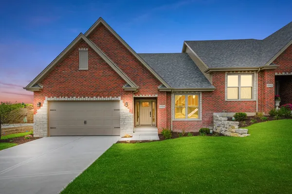 a front view of a house with a garden and yard
