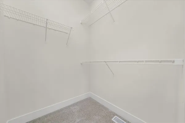an empty room with a chandelier fan and closet