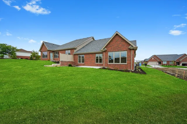 a front view of a house with yard and green space