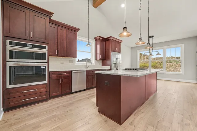 a room with kitchen island a sink and wooden floor