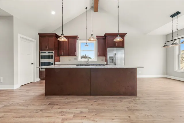 a view of a room with wooden floor a ceiling fan and a window