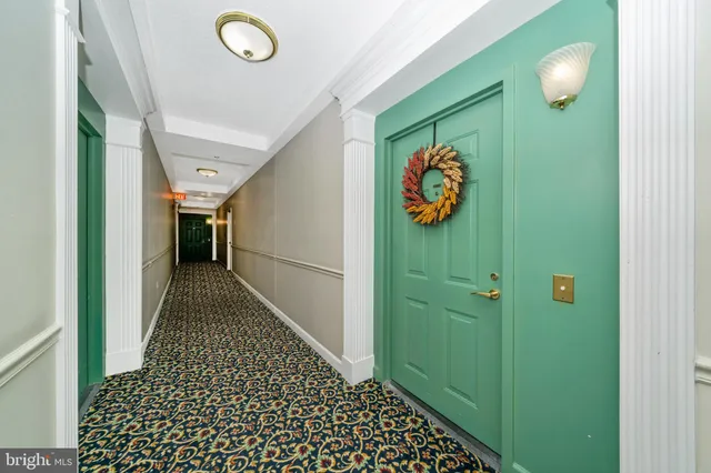 a kitchen with granite countertop a refrigerator stove and white cabinets with wooden floor