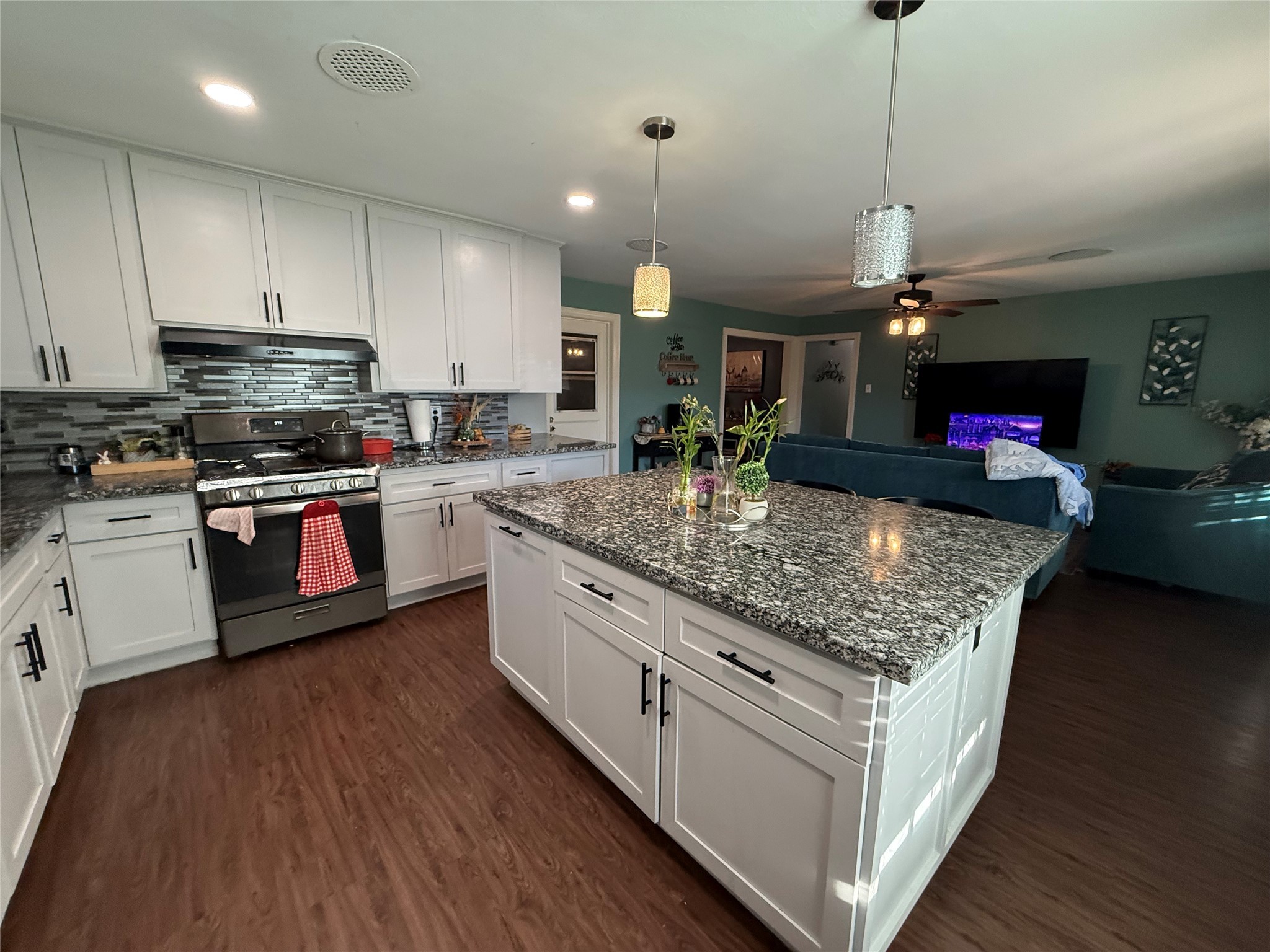 8823 Shadow Crest Street Houston, TX 77074 - Photo 3 of 14 a kitchen with kitchen island granite countertop a sink cabinets and wooden floor