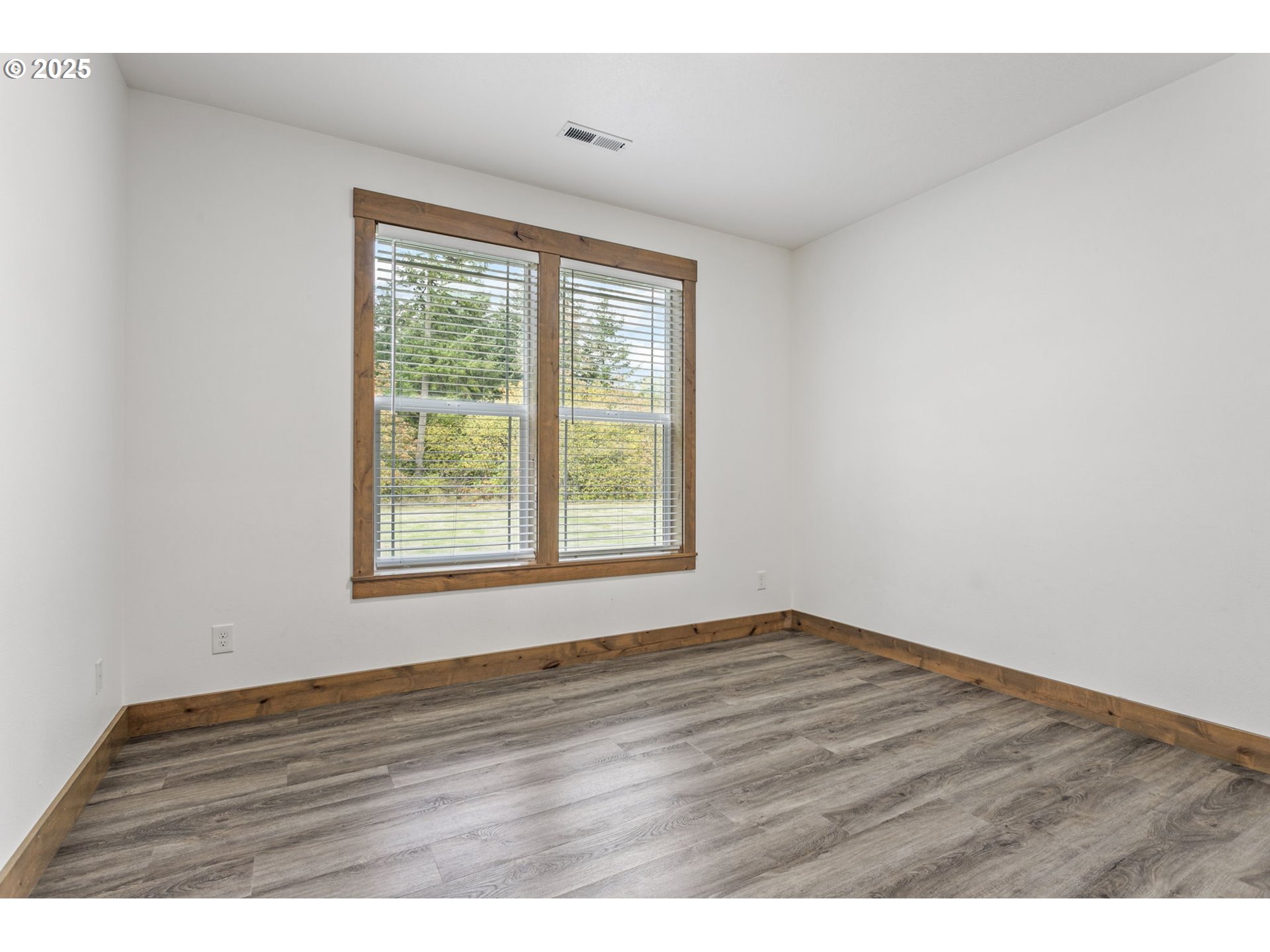 5711 Northeast 246th Street Ridgefield, WA 98642 - Photo 24 of 47 a view of an empty room with wooden floor and a window