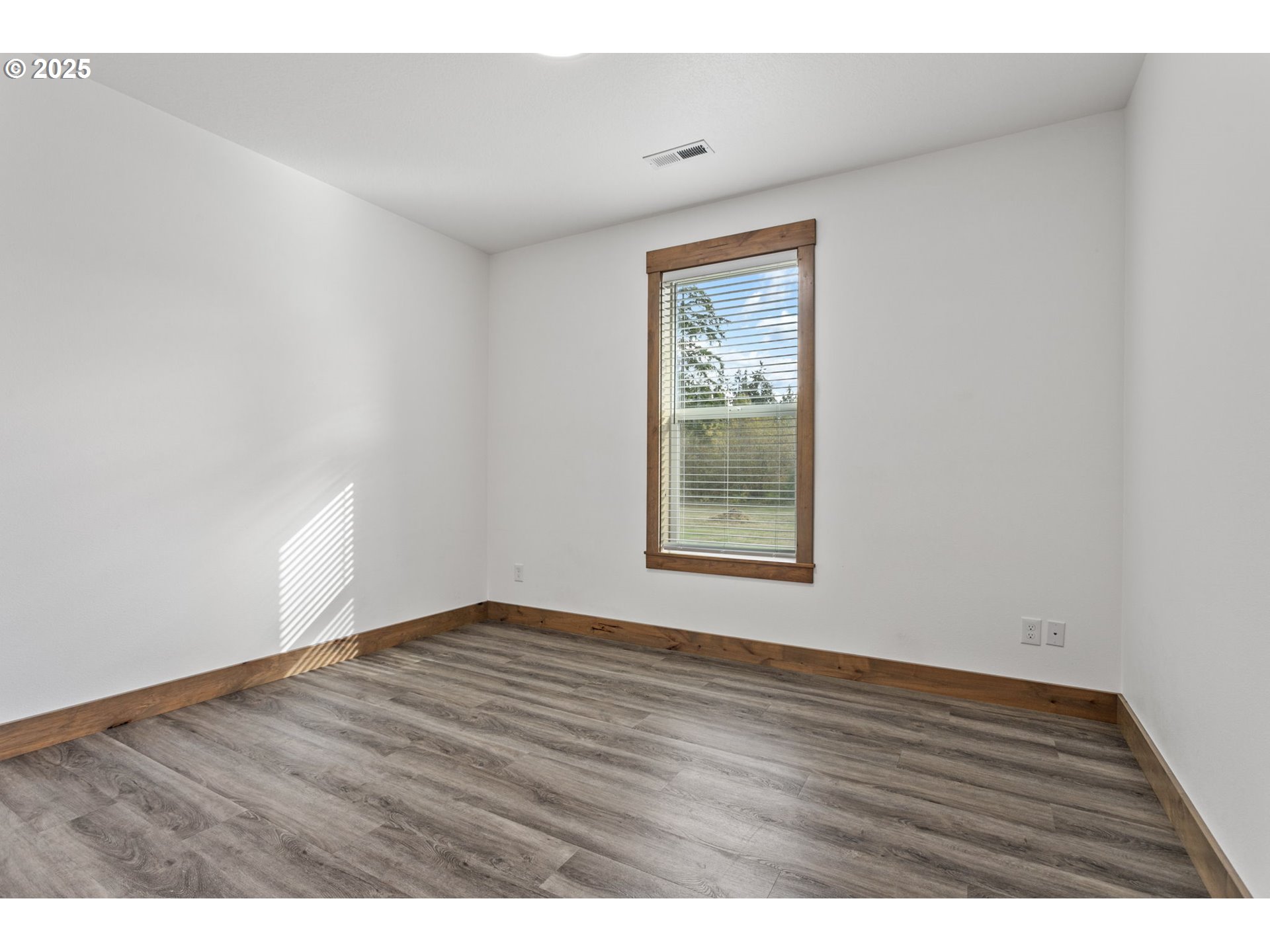 5711 Northeast 246th Street Ridgefield, WA 98642 - Photo 27 of 47 a view of an empty room with wooden floor and a window