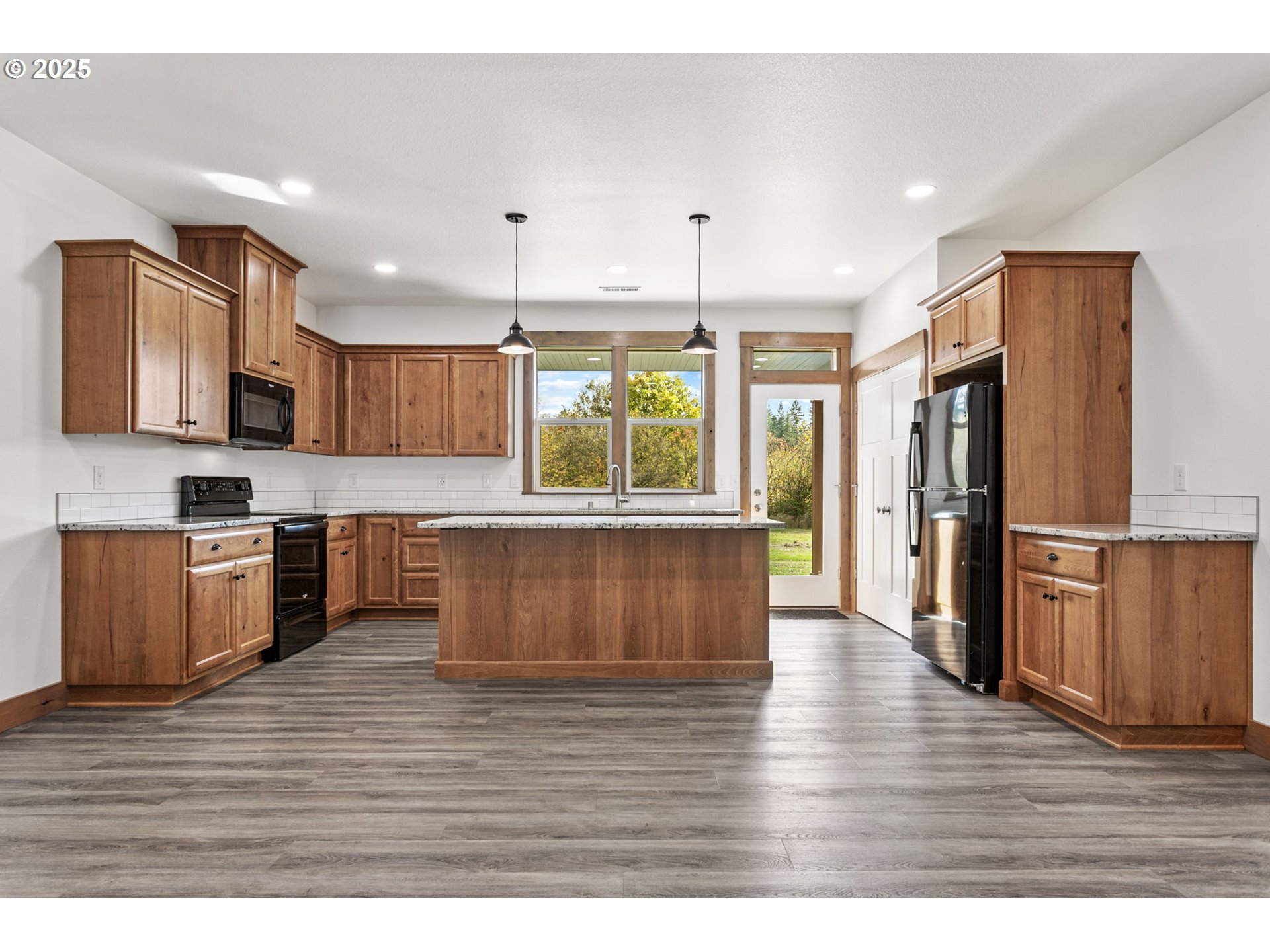 5711 Northeast 246th Street Ridgefield, WA 98642 - Photo 8 of 47 a kitchen with stainless steel appliances wooden floors and wooden cabinets