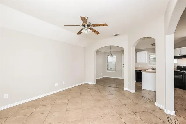 an empty room with windows and chandelier
