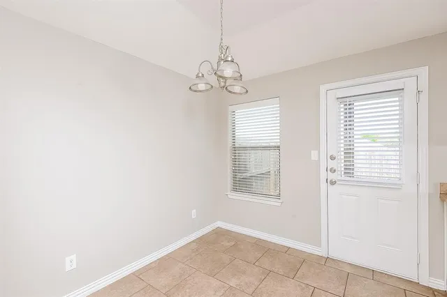 a kitchen with granite countertop a sink a stove top oven and cabinetry