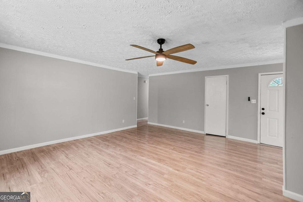 1248 Cannonville Road LaGrange, GA 30240 - Photo 19 of 46 a view of a big room with wooden floor and a ceiling fan