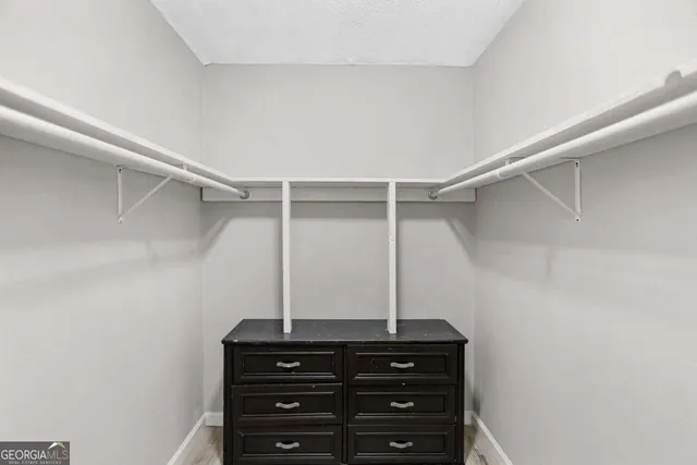 a view of a closet with wooden floor