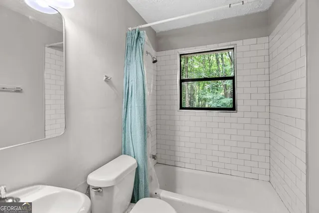 a white toilet sitting next to a bath tub