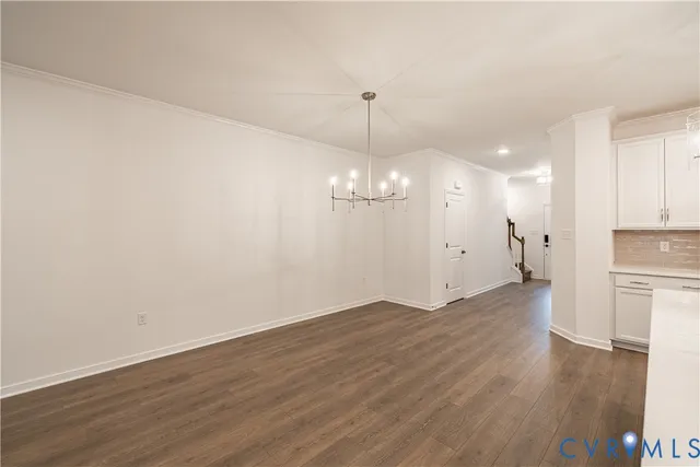 a view of a room with wooden floor and kitchen view