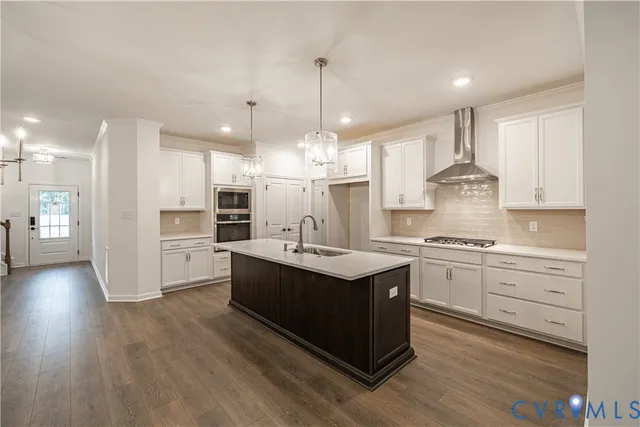 a kitchen with kitchen island granite countertop a sink cabinets and stainless steel appliances