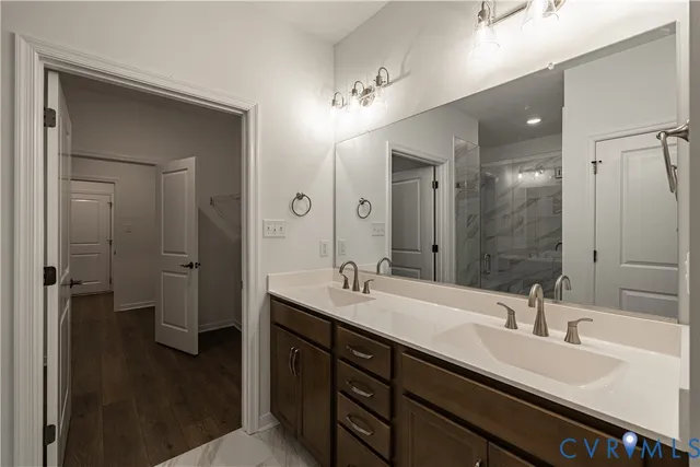 a bathroom with a double vanity sink a mirror and a shower