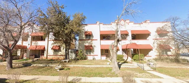 a view of a brick building next to a yard