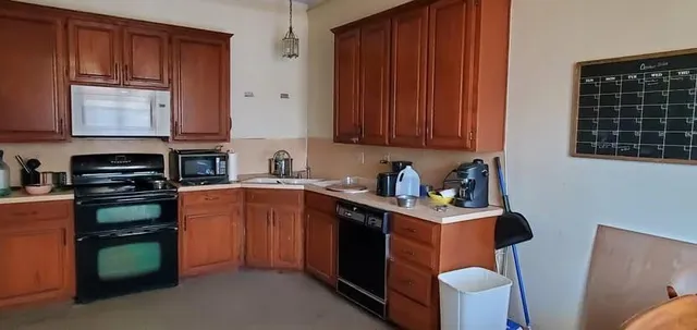 a kitchen with stainless steel appliances granite countertop a stove a sink dishwasher and a microwave oven with cabinets