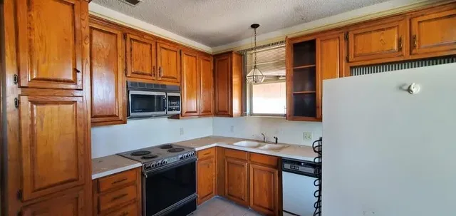 a kitchen with stainless steel appliances granite countertop a stove a sink and a refrigerator