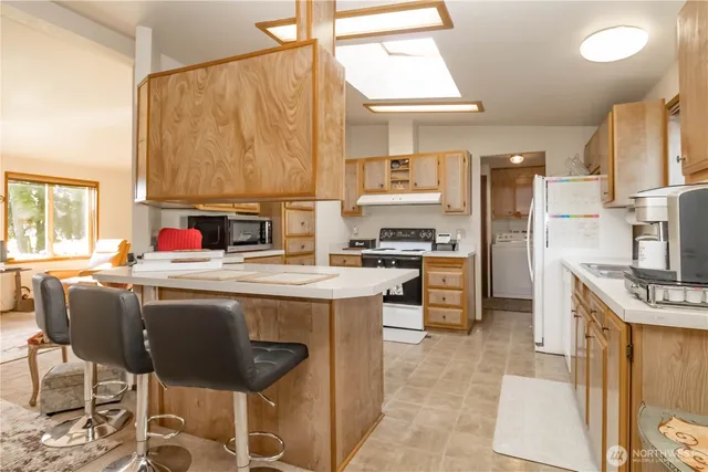 a kitchen with kitchen island granite countertop a sink counter and chairs