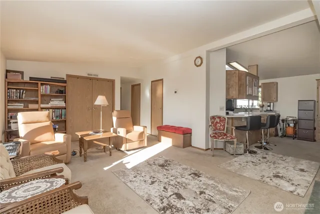 a living room with furniture and view of kitchen