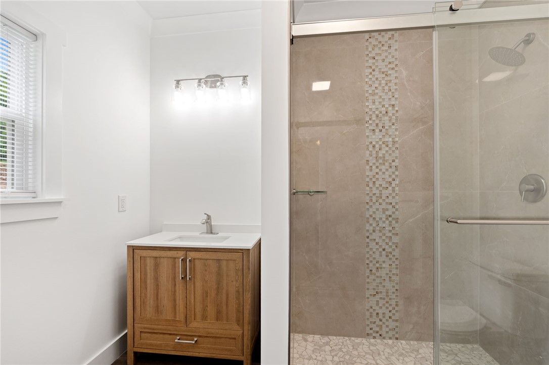 914 Smith Grove Road Easley, SC 29640 - Photo 23 of 37 A well-lit bathroom showcases a contemporary vanity and a spacious, tiled shower.