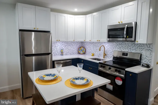 a kitchen with stainless steel appliances a stove a microwave a sink and cabinets