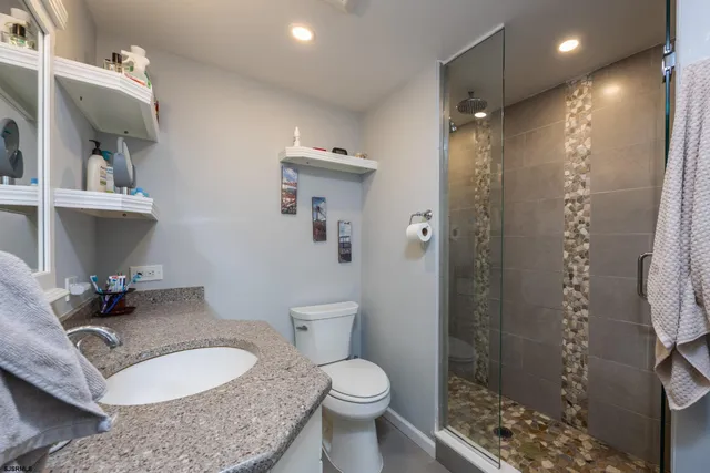 a bathroom with a granite countertop sink toilet and shower