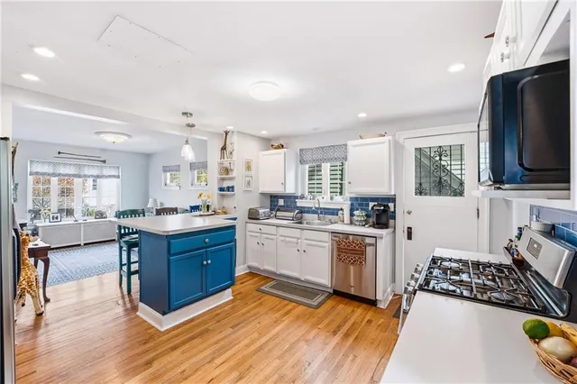 a large kitchen with stainless steel appliances granite countertop a stove and a sink