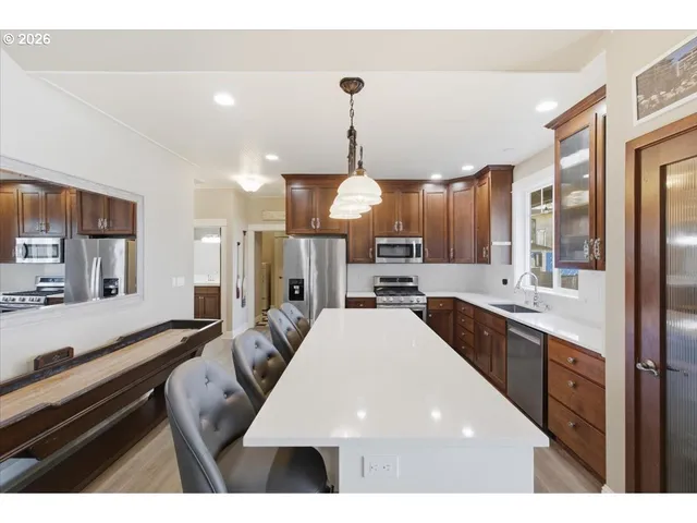 a kitchen with stainless steel appliances granite countertop a stove a sink and a refrigerator