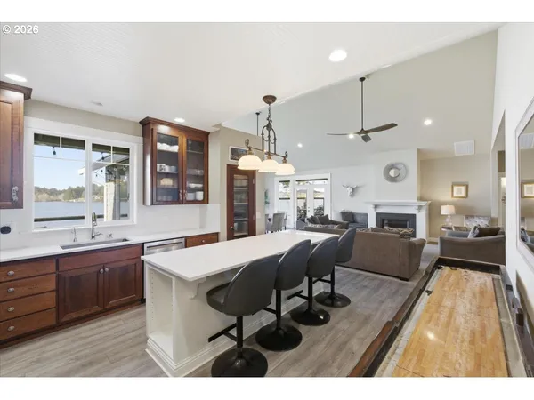 a dining room with stainless steel appliances kitchen island granite countertop a table chairs and a refrigerator