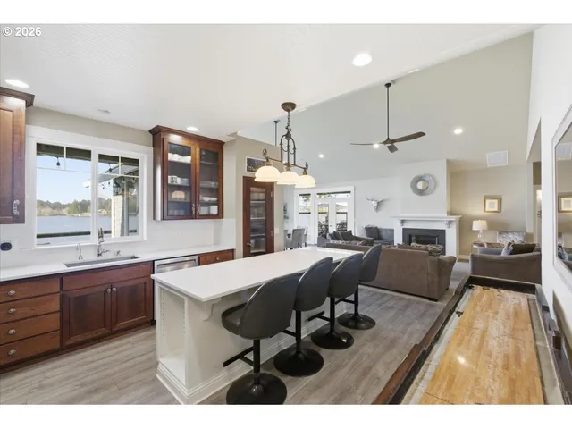 a dining room with stainless steel appliances kitchen island granite countertop a table chairs and a refrigerator