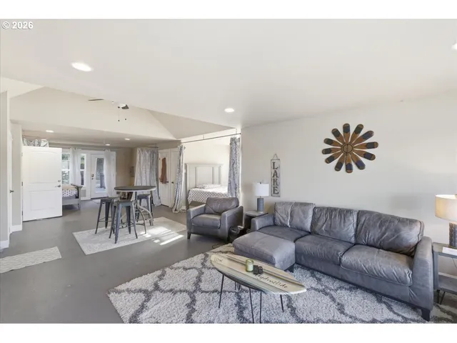 a living room with furniture a flat screen tv and a floor to ceiling window