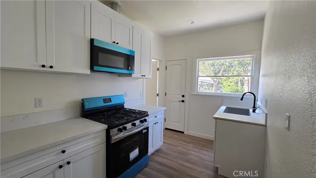 a kitchen with stainless steel appliances granite countertop a sink stove and microwave