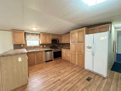 a kitchen with granite countertop stainless steel appliances and wooden cabinets