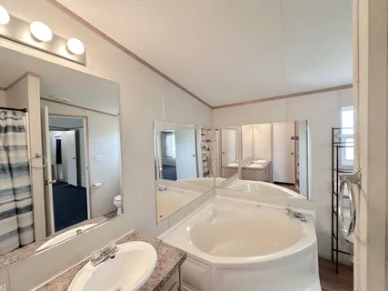 a spacious bathroom with a tub sink and mirror