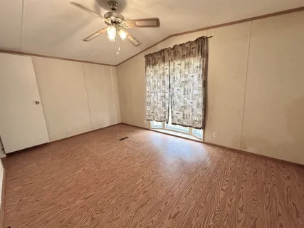 a view of a livingroom with a ceiling fan and window